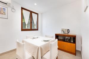 Un comedor con mesa y sillas y un microondas. en Apartments Mare, en Malinska