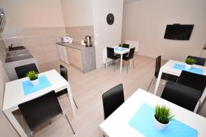 a room with tables and chairs and a kitchen at G'HOSTEL in Deszczno