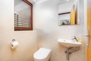 Un baño blanco con inodoro y lavabo. en Apartments Mare, en Malinska 54 fotos más
