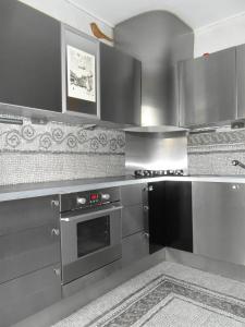 una cocina con armarios de acero inoxidable y horno en Comfy & Cosy Apartment, en Katowice