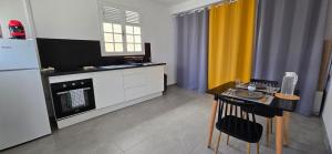 uma cozinha com uma mesa e uma geladeira em La Fleur Doré Studio em Le Vauclin