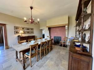 a dining room with a wooden table and chairs at Les Forges dOrval in Abbaye dʼOrval