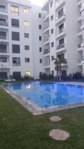 カサブランカにあるBeautiful apartment 2 bedrooms living room aéroport mohamed 5 nouaceur Casablancaの建物の前の大きなプール