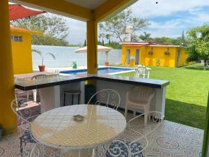 a patio with a table and chairs and a pool at "Casa San Miguel" Alberca privada, jardín, wifi, proyector,asador a 15 min de Cuautla en Morelos in Tlayecac