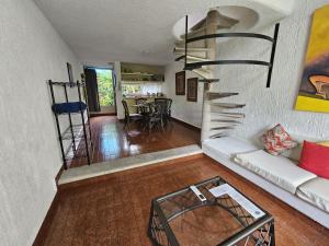 a living room with a spiral staircase in a house at Hotel Villas Las Anclas in Cozumel