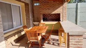 a patio with a table and chairs and a stove at Apart Los Tilos 4 pax in Chascomús +11 photos