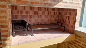 a brick wall with a bench in front of a fireplace at Apart Los Tilos 4 pax in Chascomús