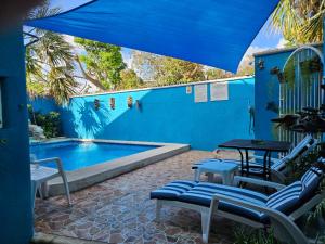 a patio with a table and chairs next to a pool at Hotel Villas Las Anclas in Cozumel