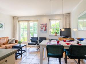 a living room with a table and chairs at De Steeneik in Oostdorp