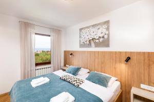 Un dormitorio con una cama grande con ventana. en Apartments Cerovic, en Malinska