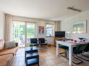 a living room with a table and a couch at De Steeneik in Oostdorp
