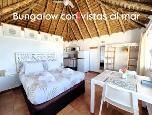 a bedroom with a bed and a table and a kitchen at Mandala Bungalows - Adults Only in Los Caños de Meca