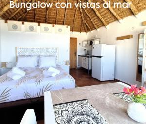 a bedroom in a villa with a bed and a kitchen at Mandala Bungalows - Adults Only in Los Caños de Meca