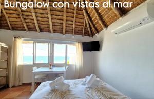 a bedroom with a bed and a table and a window at Mandala Bungalows - Adults Only in Los Caños de Meca