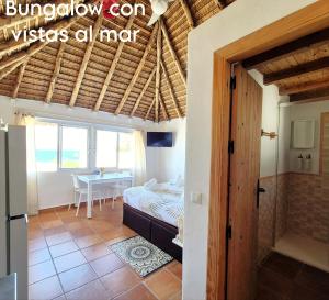 a bedroom with a bed and a table in a room at Mandala Bungalows - Adults Only in Los Caños de Meca