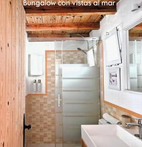 a bathroom with a shower with a sink and a mirror at Mandala Bungalows - Adults Only in Los Caños de Meca