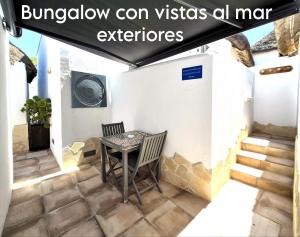 a table and chairs on a patio with a sign that reads burnaby can at Mandala Bungalows - Adults Only in Los Caños de Meca