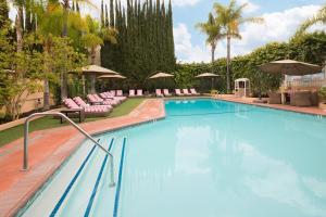 a large swimming pool with chairs and umbrellas at Hollywood Hotel in Los Angeles