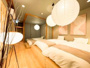 Una habitación con cuatro camas con sábanas blancas y luces. en Gold Rich, en Sapporo