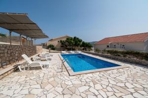a patio with a pool and chairs and a house at Studio Zubovici 9365b in Zubovići