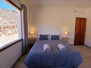 a bedroom with a large bed with two towels on it at Casa Florencia in Cachí