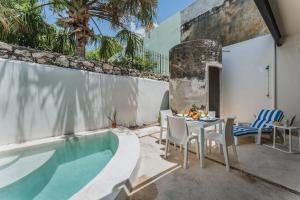 a patio with a table and chairs next to a swimming pool at Casa Tropical in Mérida