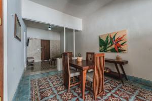 Un comedor con mesa y sillas de madera. en Casa Tropical, en Mérida