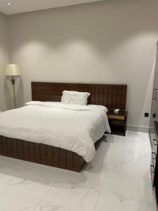 een slaapkamer met een groot bed met witte lakens bij أركان نموذجية in Riyad