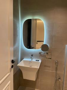 een badkamer met een witte wastafel en een spiegel bij أركان نموذجية in Riyad