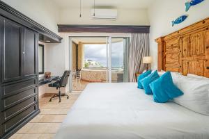 a bedroom with a bed with a desk and a window at Stunning 2 BR with Ocean Views & Jacuzzi by the Beach in Cabo San Lucas