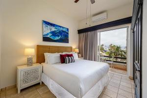 a bedroom with a bed and a large window at Stunning 2 BR with Ocean Views & Jacuzzi by the Beach in Cabo San Lucas +53 photos