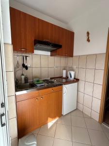 a small kitchen with wooden cabinets and a white refrigerator at Apartment Orebic 10082b in Orebić