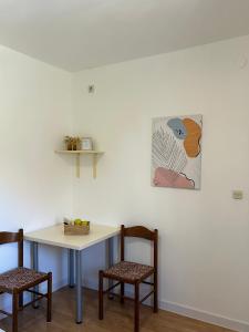 a table and two chairs and a table and a painting at Apartment Orebic 10082b in Orebić +23 photos