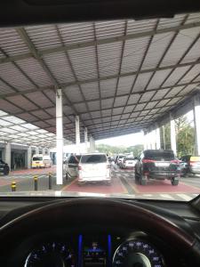 a view from a car dashboard of a parking lot with cars at Hotel in Puunggolaka