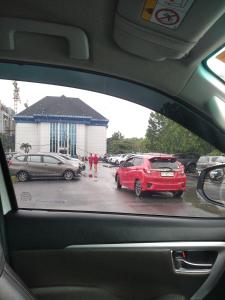 a view from a car window of a parking lot with cars at Hotel in Puunggolaka
