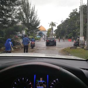 a view from a car dashboard of a street with cars and people at Hotel in Puunggolaka