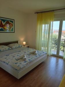 a bedroom with a large bed and a large window at Apartments with parking space Novi Vinodolski - 2416 in Novi Vinodolski