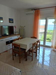 a kitchen with a table and chairs and a television at Apartments with parking space Novi Vinodolski - 2416 in Novi Vinodolski +20 photos