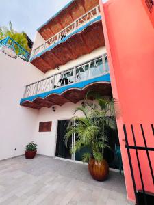 a building with a palm tree in front of it at Villa Los Corales in Sayulita