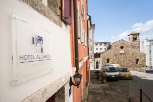 a sign on the side of a building on a street at Hotel All'Arco in Trieste