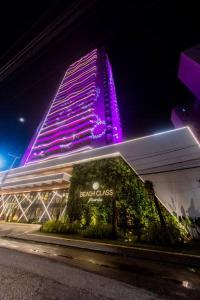 ein Gebäude mit lila Lichtern in der Nacht in der Unterkunft Beach Class Meireles Studio Mobiliado in Fortaleza