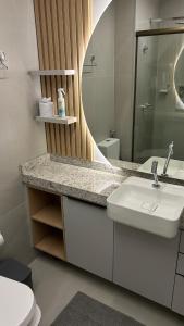 ein Badezimmer mit Waschbecken und Spiegel in der Unterkunft Beach Class Meireles Studio Mobiliado in Fortaleza