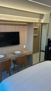 Zimmer mit einem Tisch, 2 Stühlen und einem Bett in der Unterkunft Beach Class Meireles Studio Mobiliado in Fortaleza + 12 Fotos