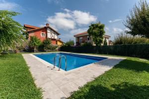 a swimming pool in a yard next to a house at Casa San Martin in Cortiguera