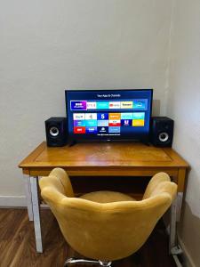 un televisor sentado sobre una mesa con una silla en Lucifer, en Londres 7 fotos más