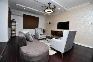 sala de estar con 2 sillas y piano en Chanan Court Apartment, en Accra
