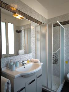a white bathroom with a sink and a shower at SG Family - Villa Secolo in Peschiera del Garda