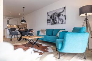 a living room with a blue couch and a table at Ferienwohnung Wiking-Koje 7 Schleswig in Schleswig