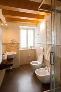 a bathroom with two sinks and a toilet and a window at Hotel All'Arco in Trieste