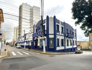 a blue and white building on a city street at Hotel Carvalho in Bragança Paulista